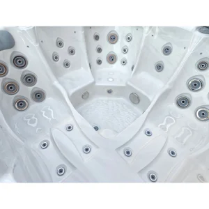 Primo piano dell'interno in acrilico bianco della spa JJSPA Gamma 323, concentrandosi sui vari tipi di getti idromassaggio (dimensione e stile) e sulle aree di seduta ergonomiche.